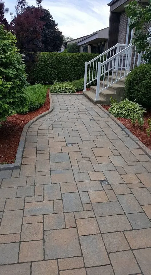 Allée en pavé aux tons terre jusqu'à l'escalier de la galerie