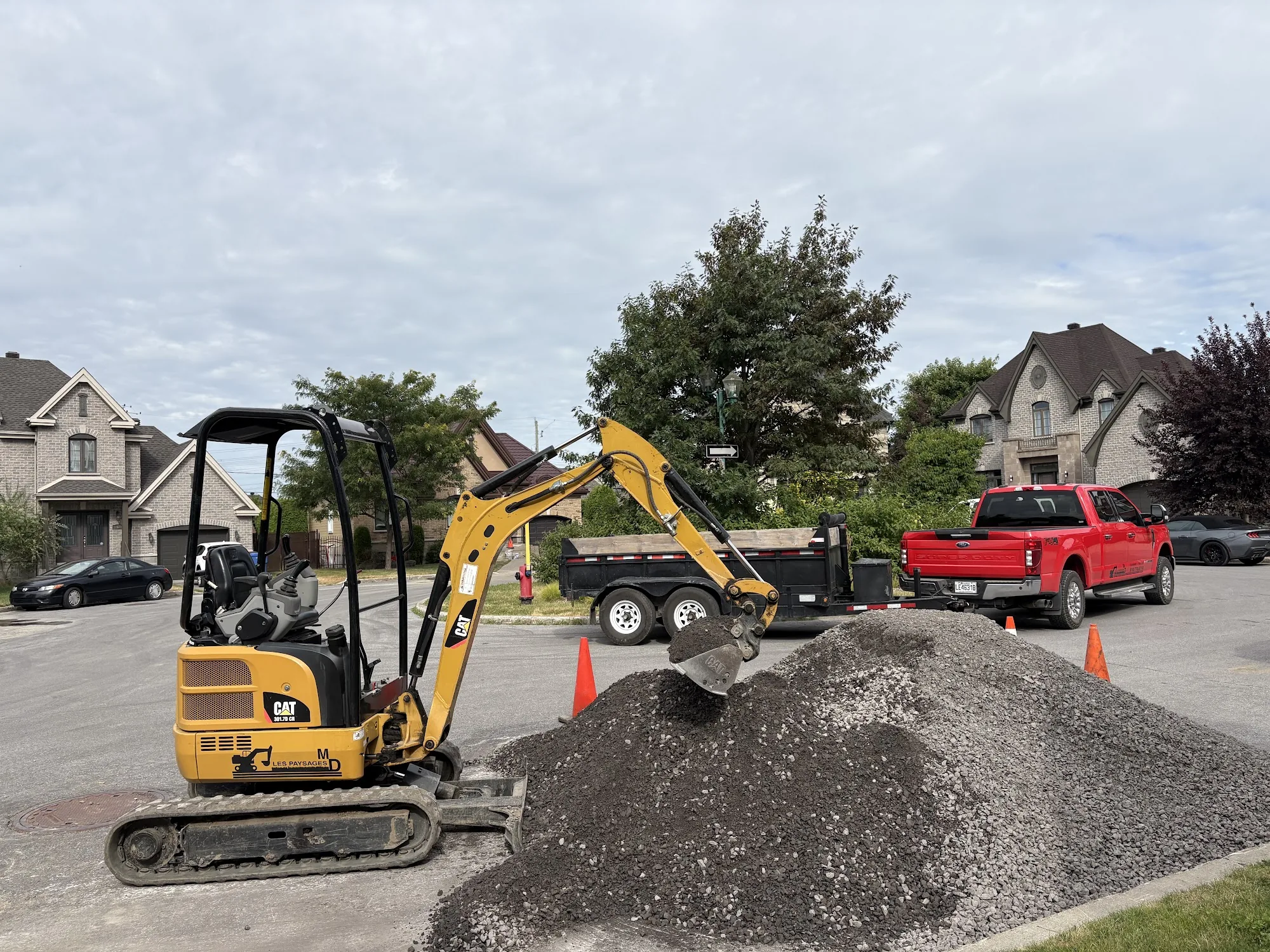 Mini-excavatrice qui étend du gravier